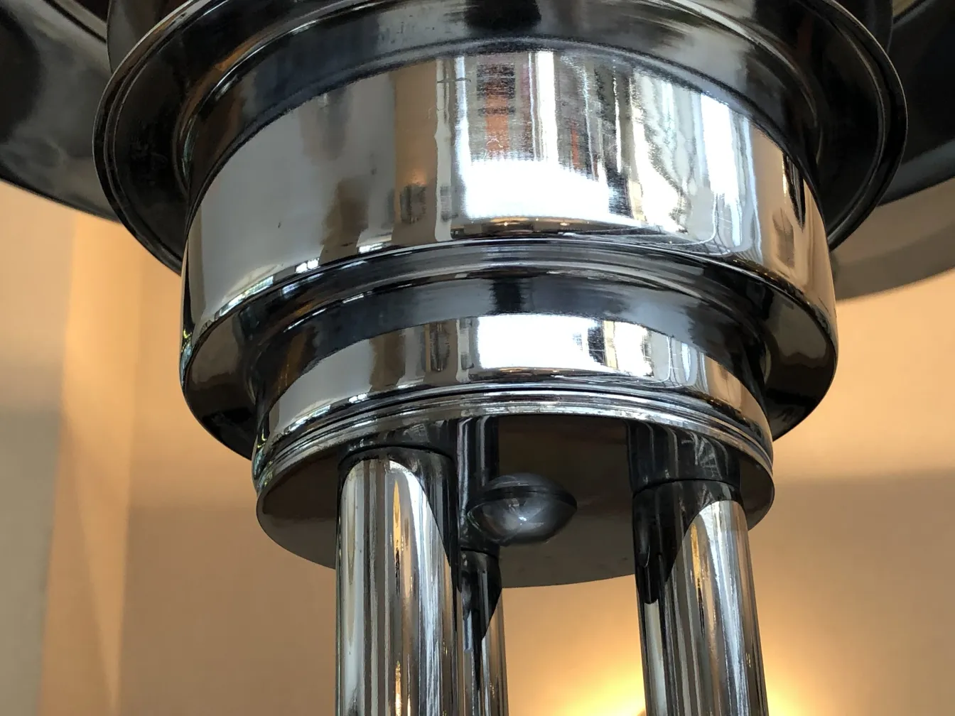 duas lâmpadas de piso antigas com superfícies brilhantes e formas elegantes em um ambiente aconchegante