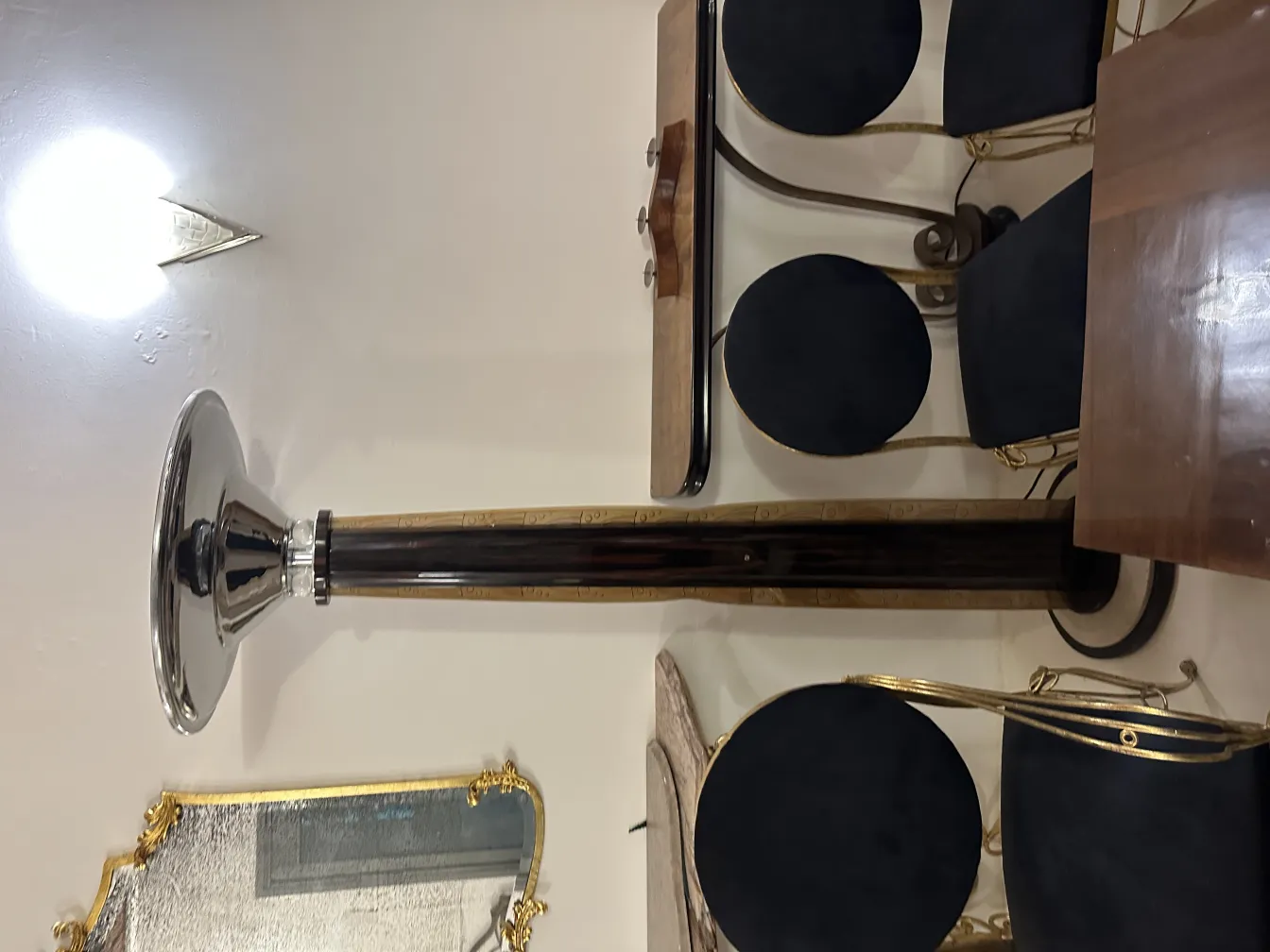 Dos lámparas de pie antiguas en un ambiente elegante, con sillas y mesa decoradas.