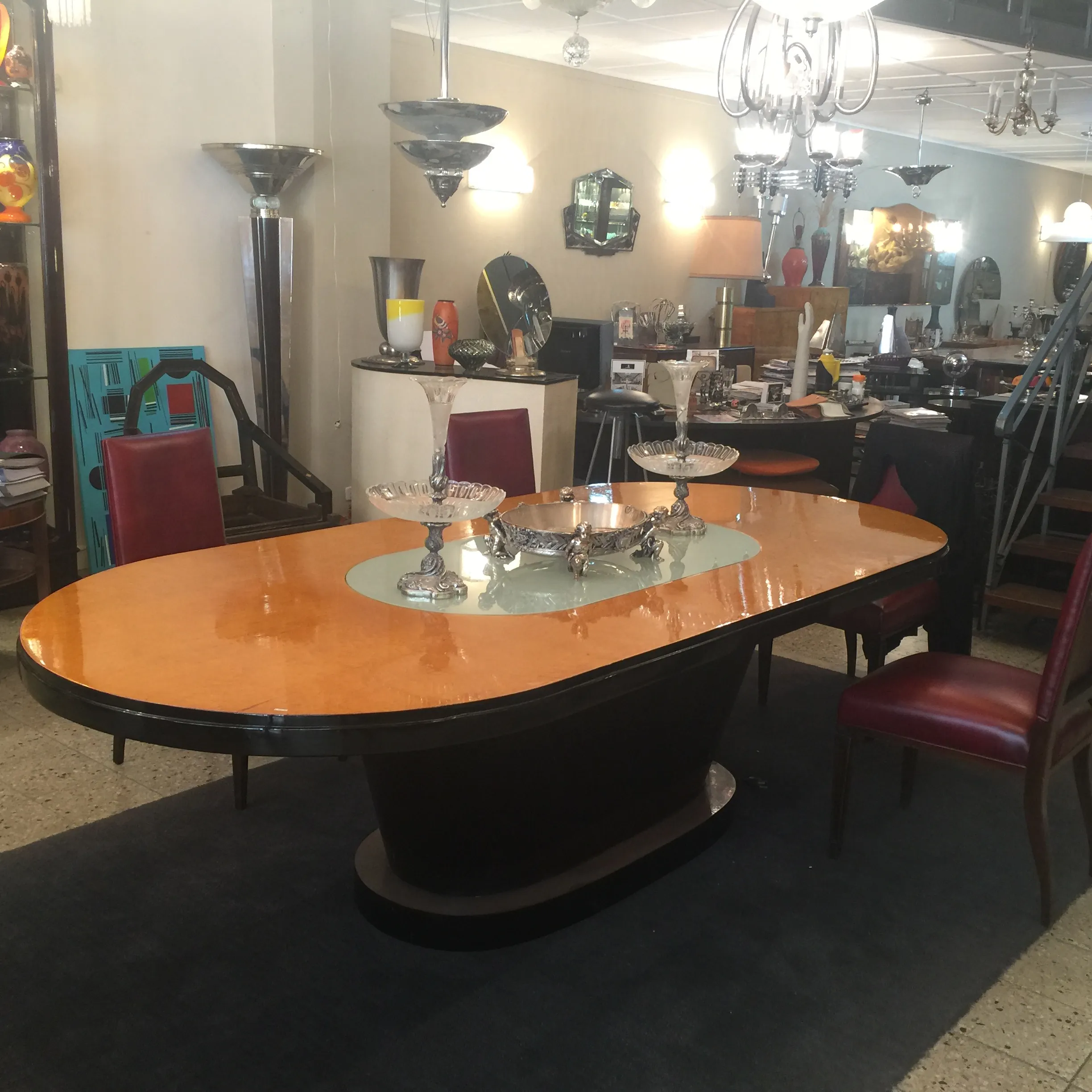 Table de repas ancienne Art Deco pour 10 personnes, entourée de chaises élégantes et de décorations.