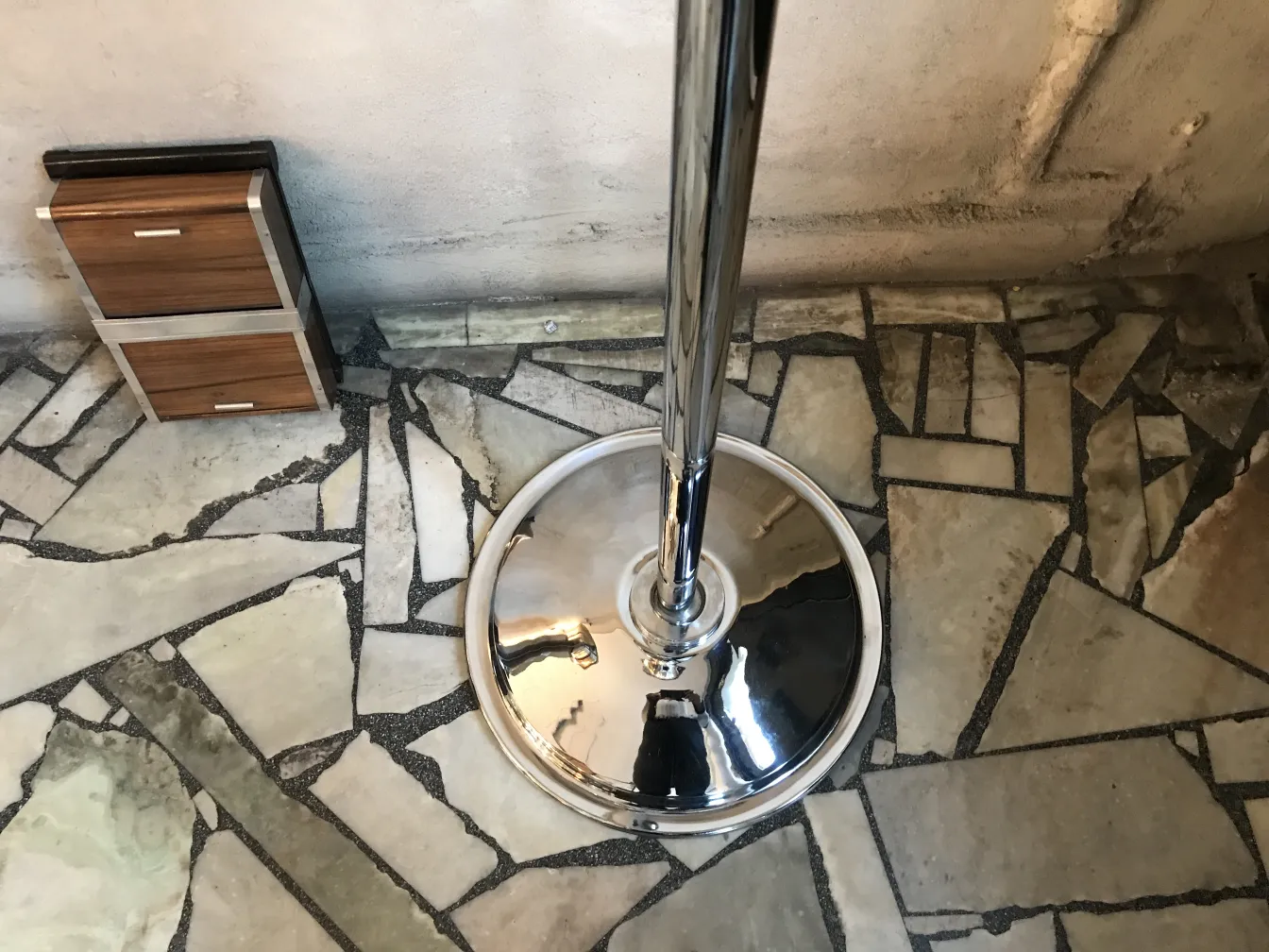 Two antique floor lamps in a stone floor setting.