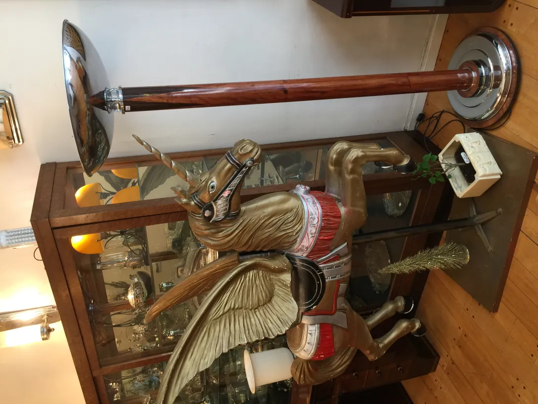 2 antique floor lamps next to a wooden decorative horse.