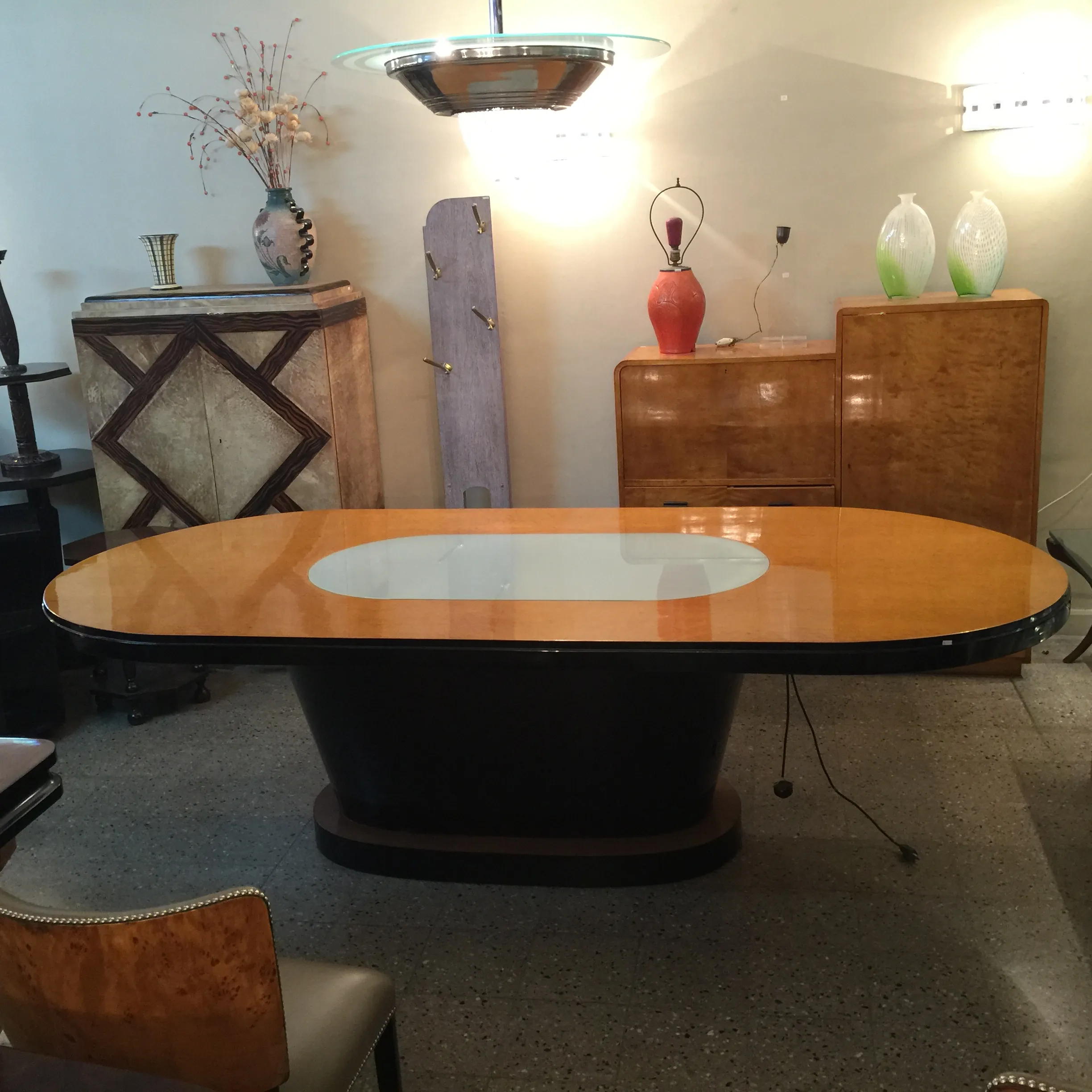 mesa de comedor antigüa art deco, ovalada, con luz, en ambiente elegante