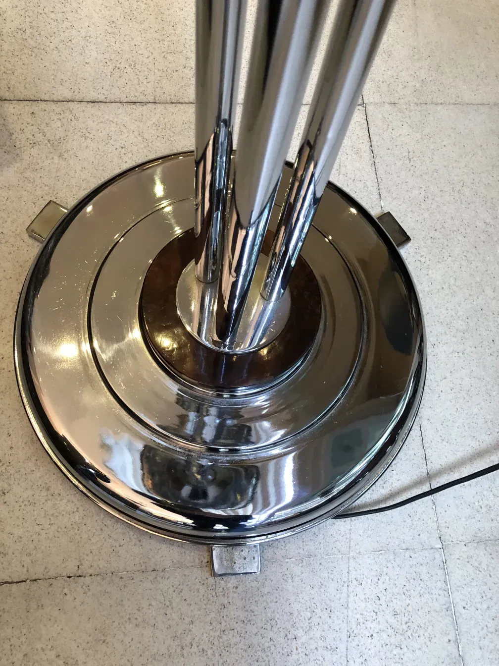 two antique floor lamps with a shiny base in a modern setting.