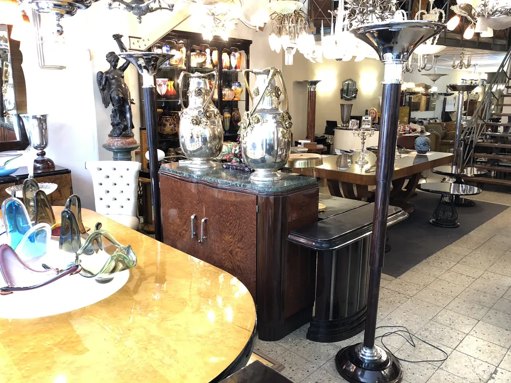 View of 2 elegant antique floor lamps in a decorative shop.