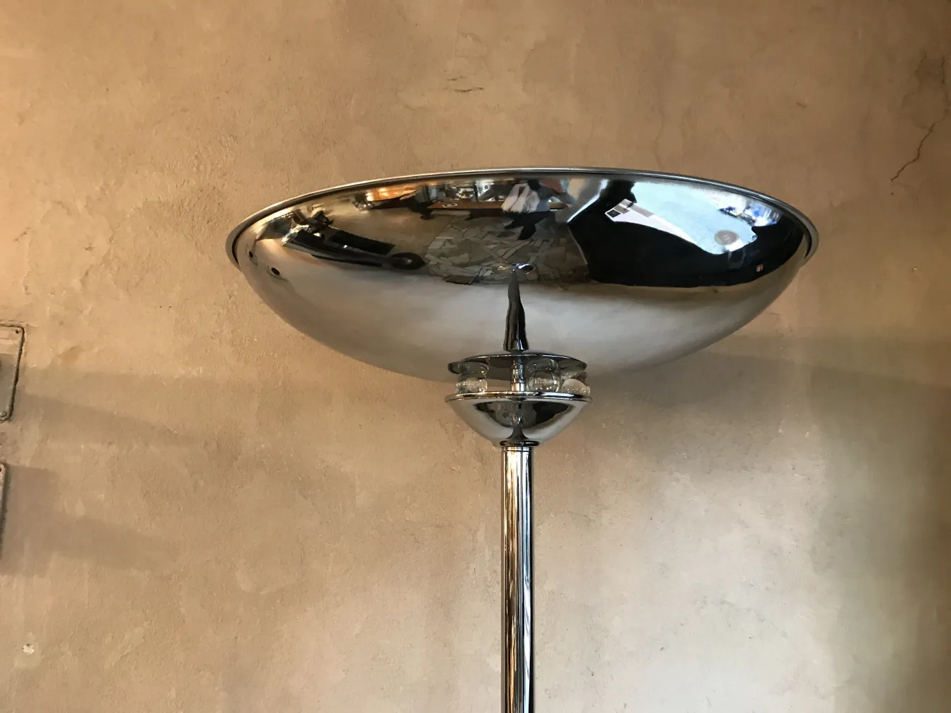 Vue du dessus de deux lampadaires anciens avec un dôme brillant contre un mur texturé.