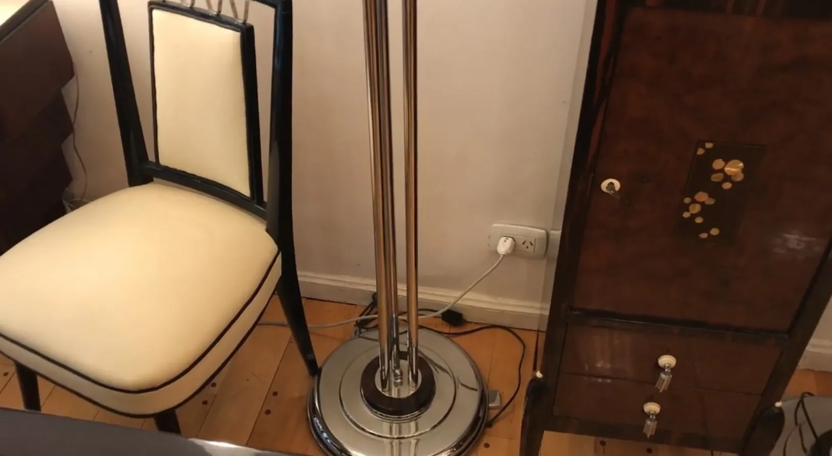 Immagine di due lampade da terra antiche accanto a una sedia e a un elegante mobile