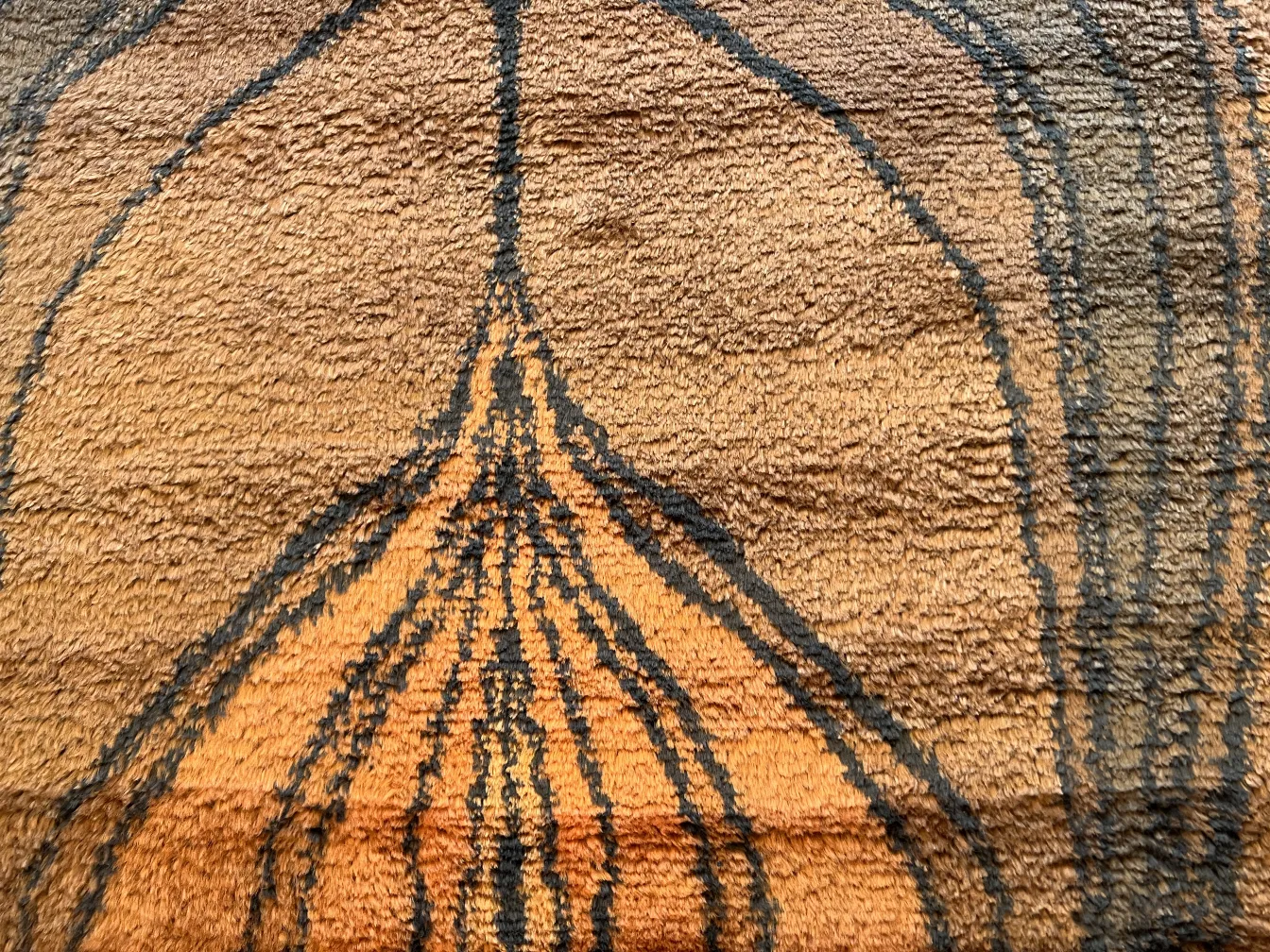 alfombra antigua con diseño en tonos marrón y negro