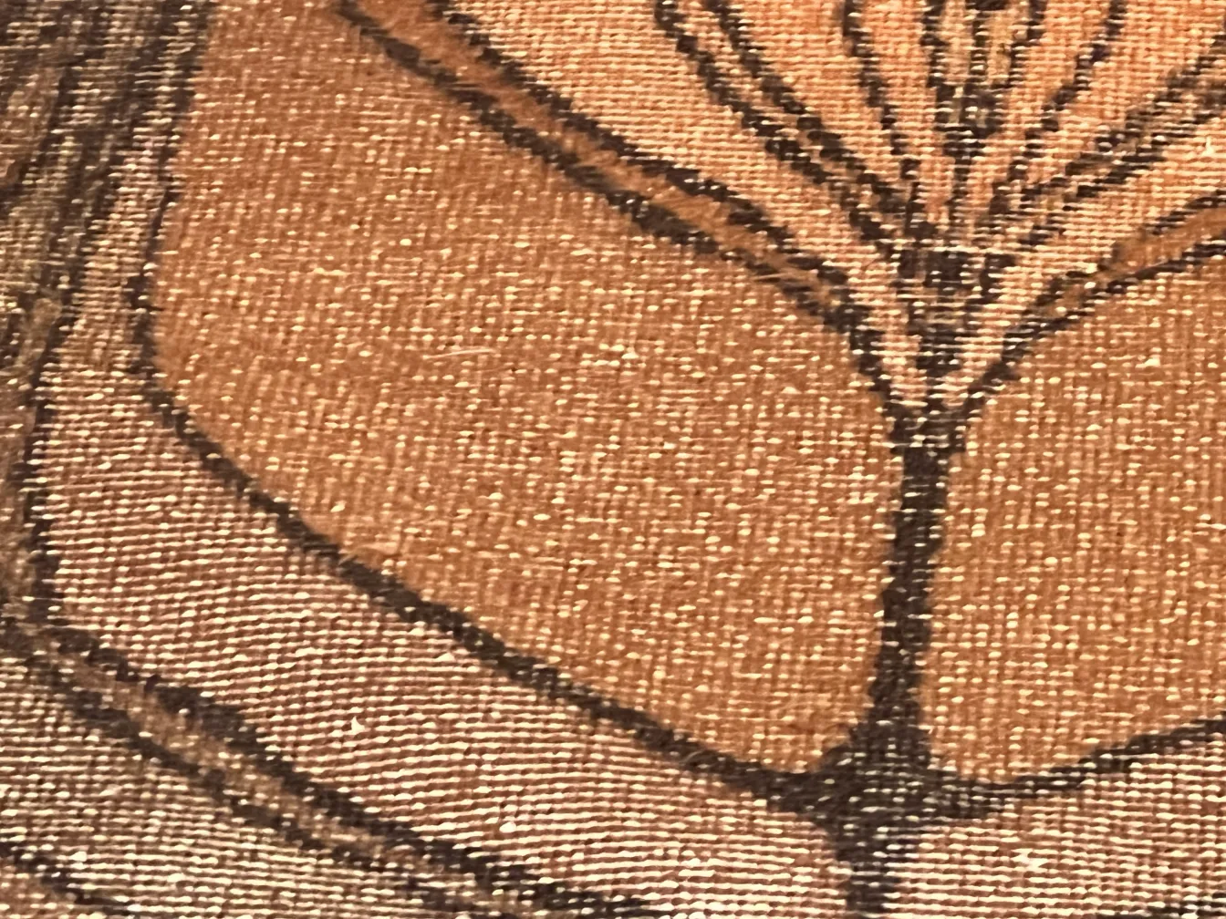 Antique decorative carpet with floral design in warm tones.