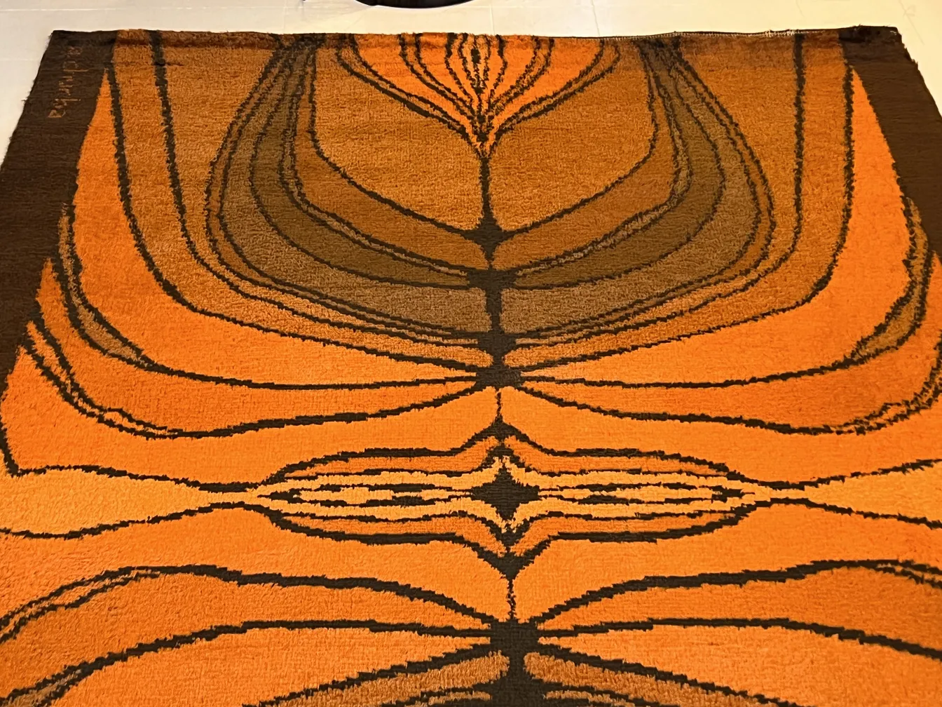 alfombra antigua con diseño de ondas en naranja y marrón