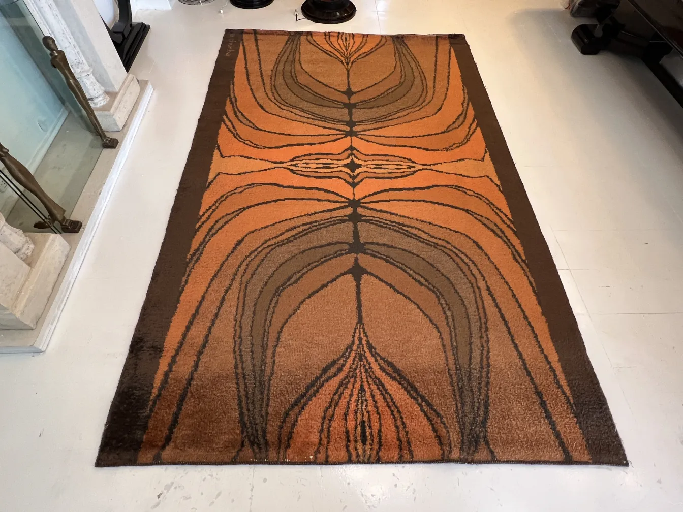 antique carpet with brown and orange patterns in a modern setting