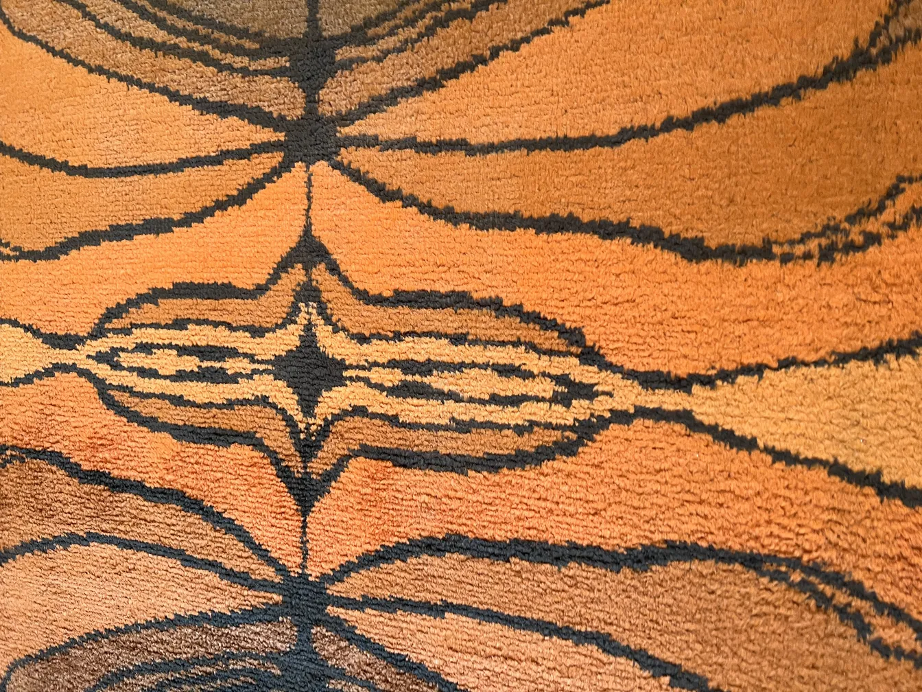 tappeto antico con design in toni caldi e scuri