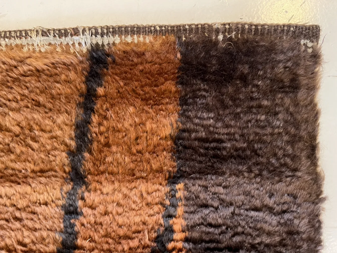 antiker Teppich mit weicher Textur in Braun- und Schwarztönen