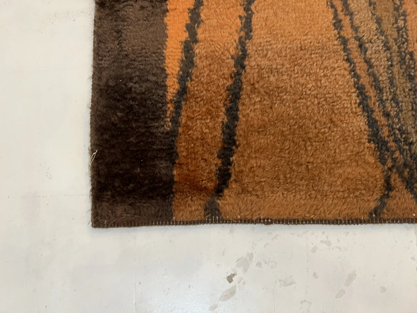 antiker teppich mit warmen braunen und orangefarbenen Tönen, gemütlicher Stil