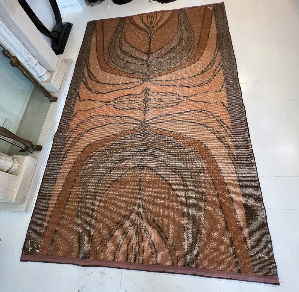 antique carpet with abstract design in earth tones