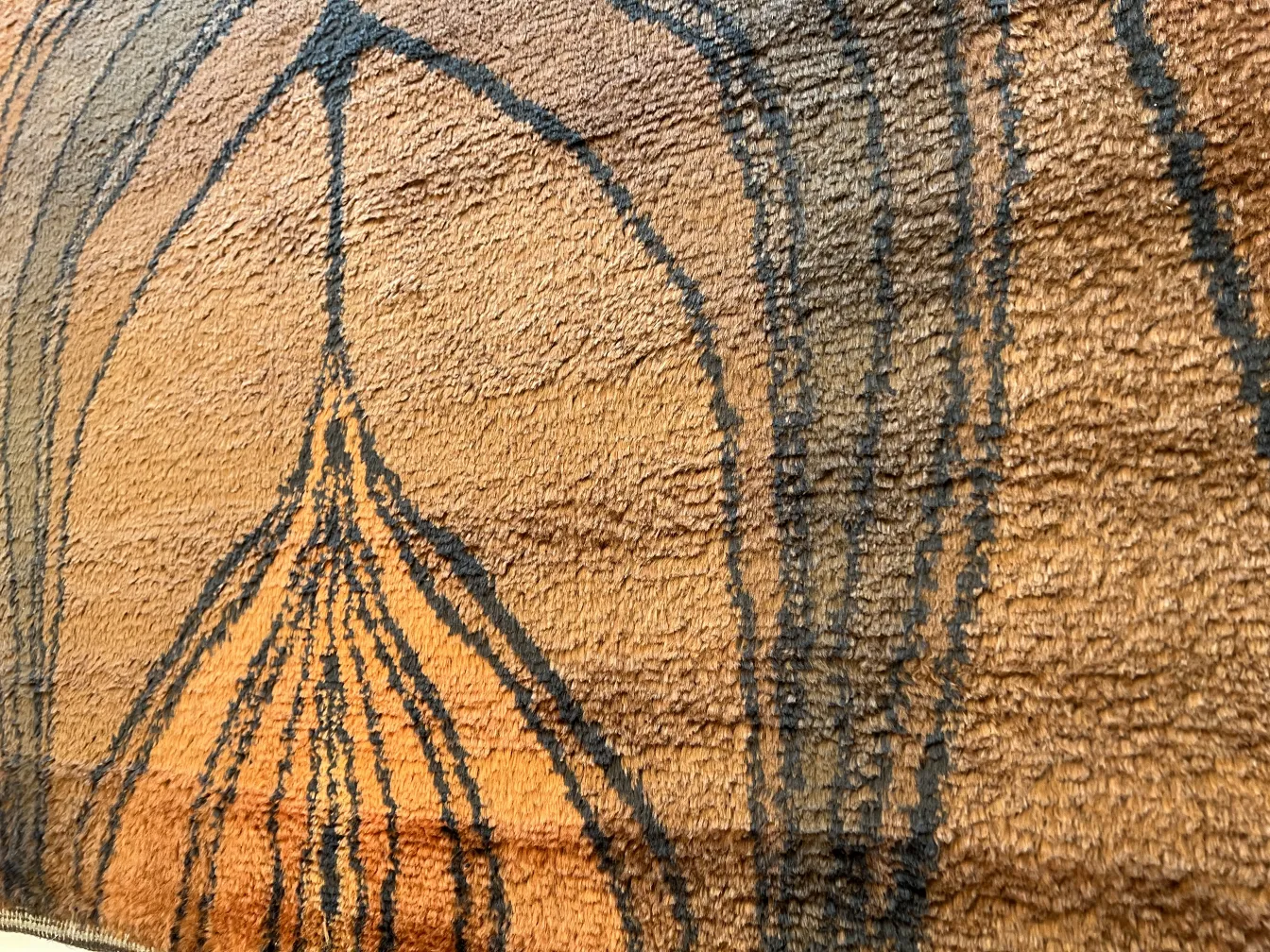 Tapis ancien avec des tons chauds et des textures uniques.