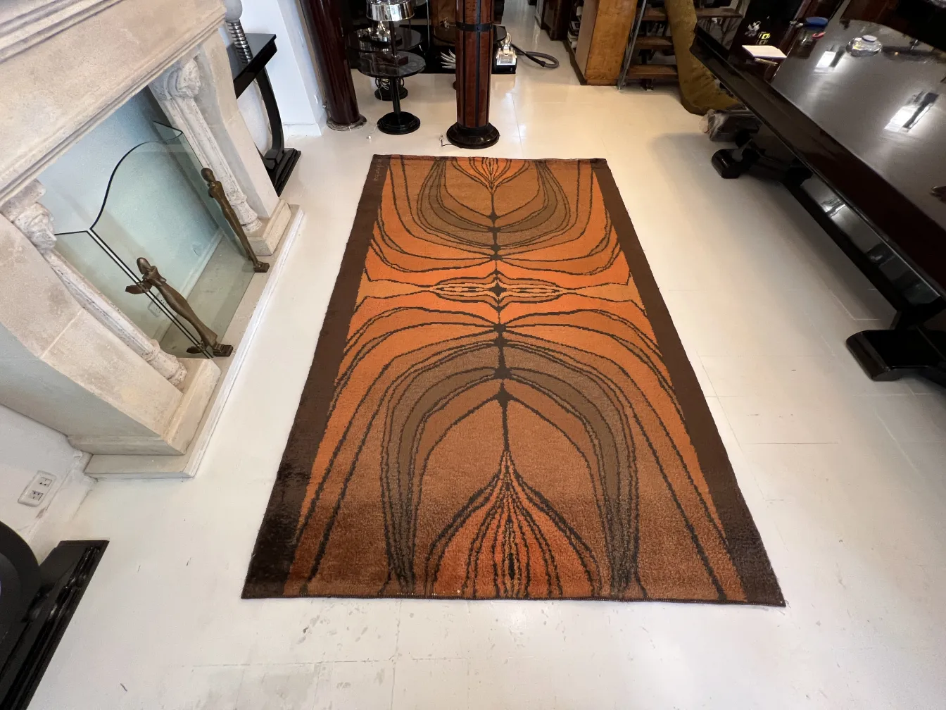 antique carpet in orange and black with artistic design in a modern setting