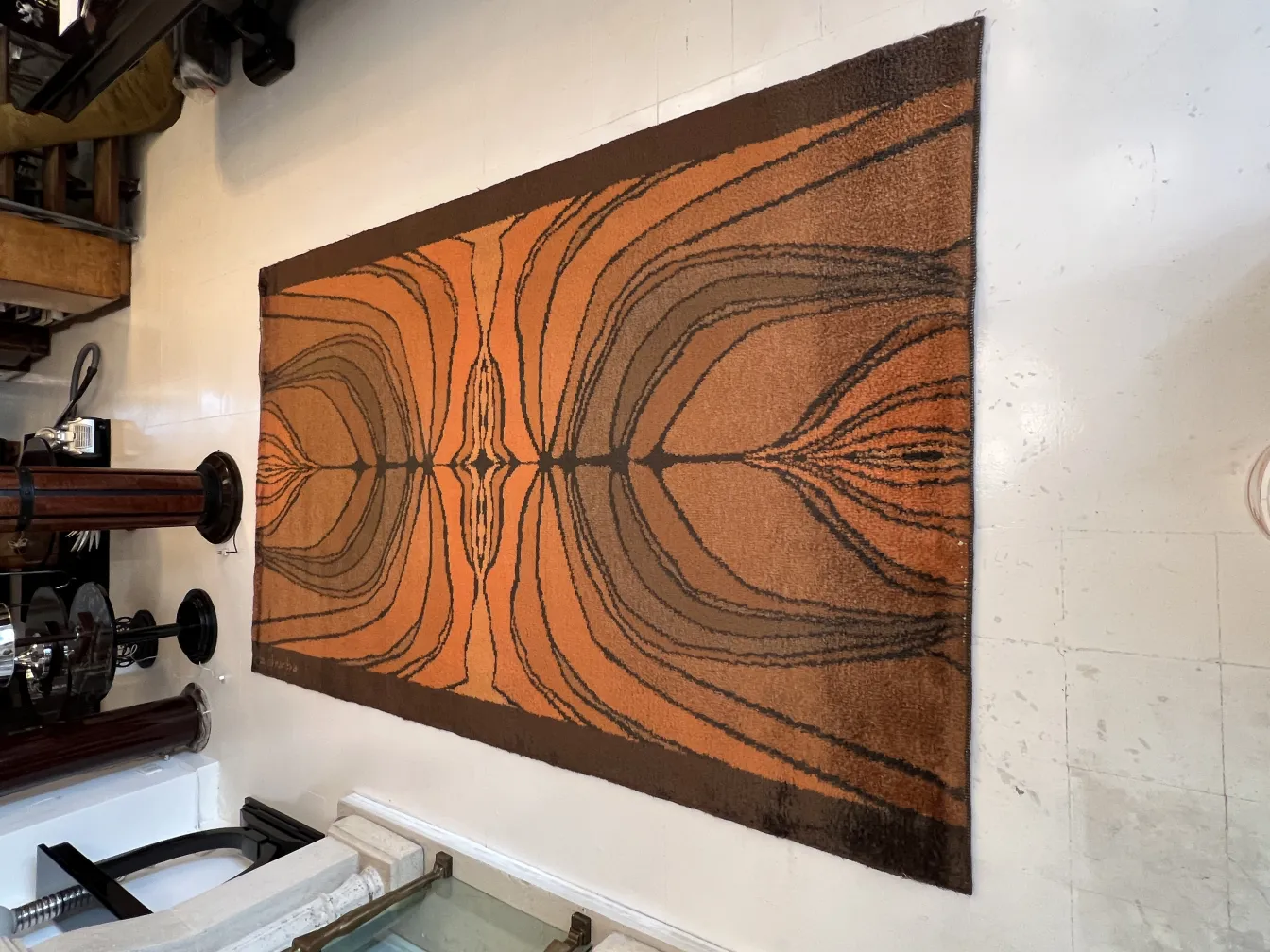 tapis ancien aux tons orange et marron dans un cadre classique