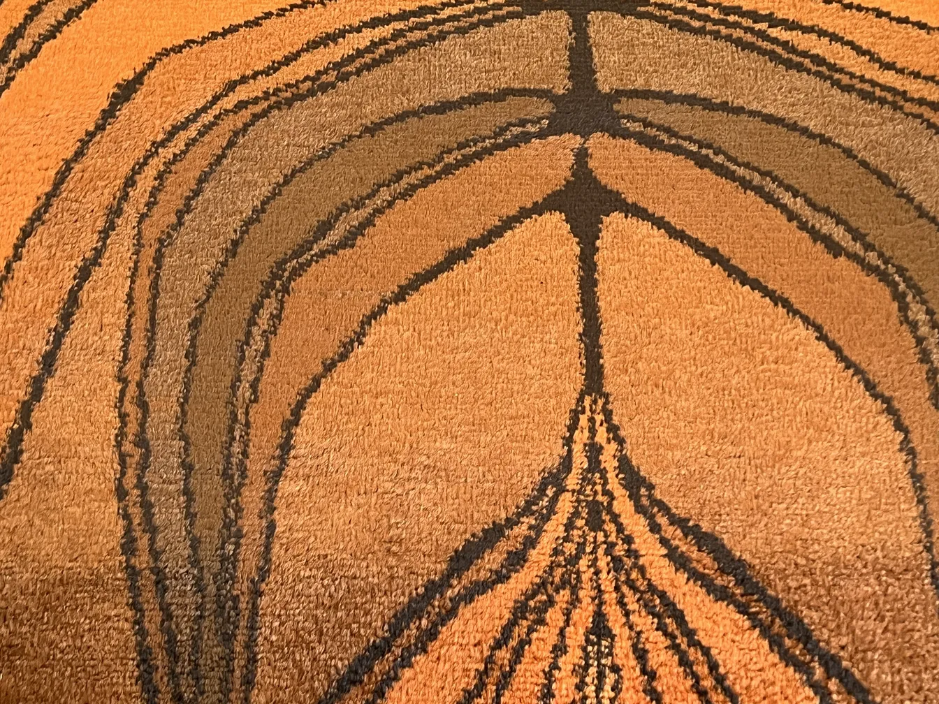 alfombra antigua en tonos marrones y negros con patrones