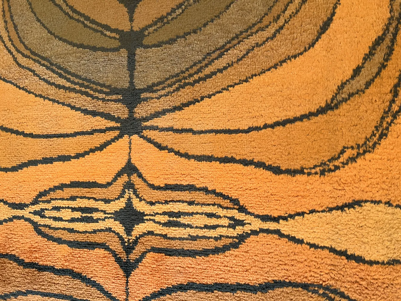 tapis ancien avec un design en motifs sur des tons chauds