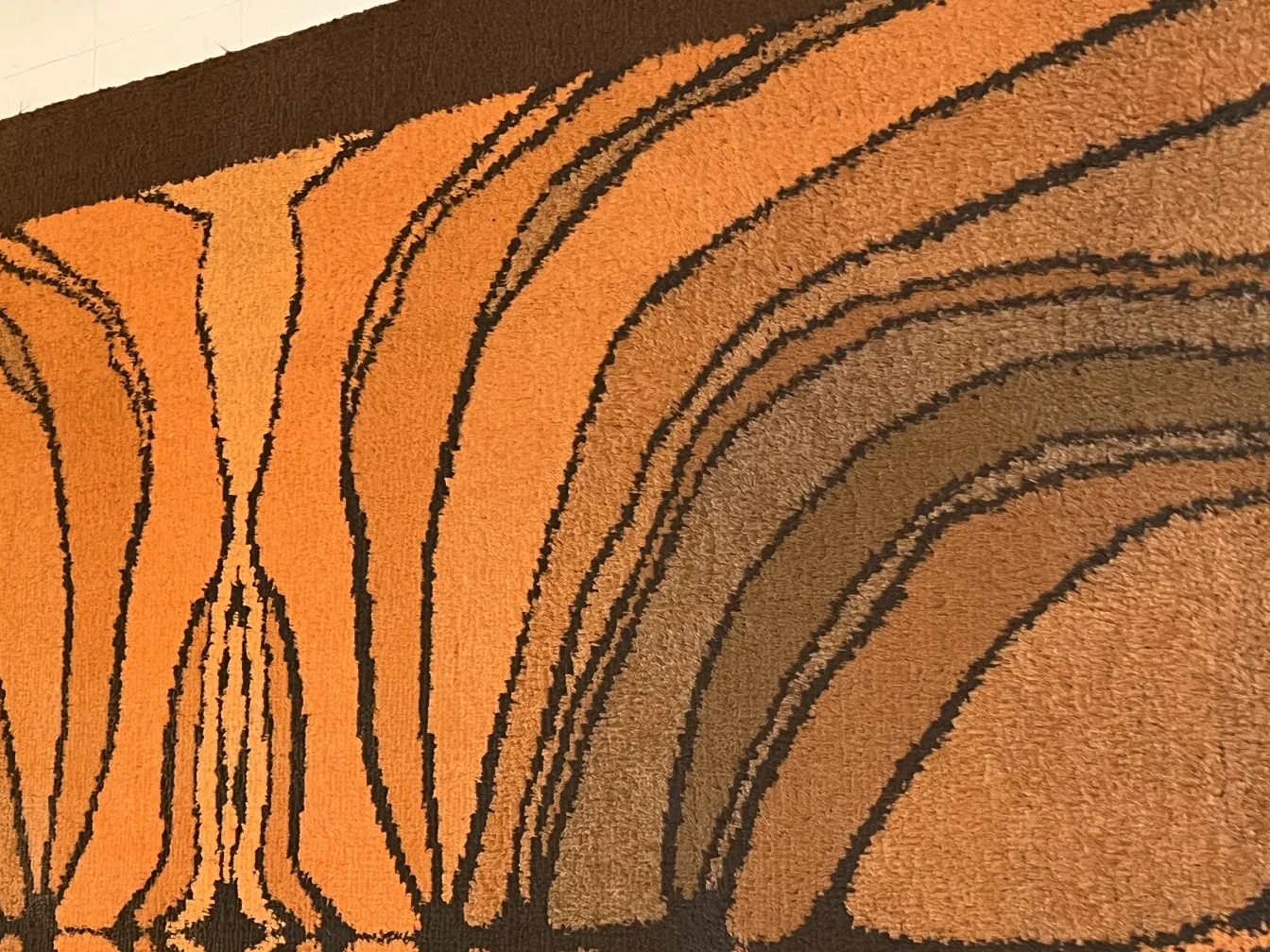 Antiker Teppich in warmen Farben mit welligem, buntem Design.