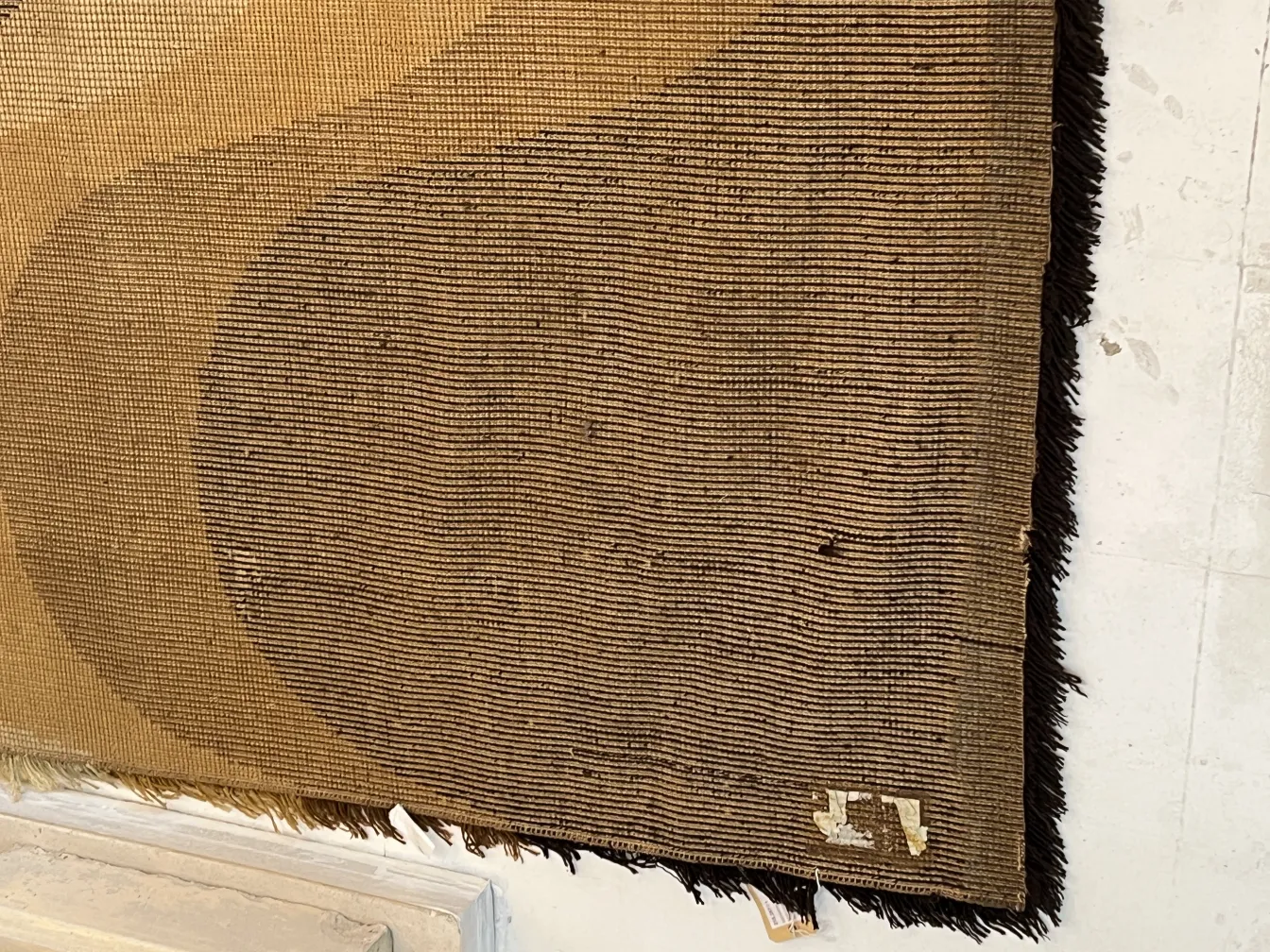 Antique carpet featuring an elegant geometric design in brown tones