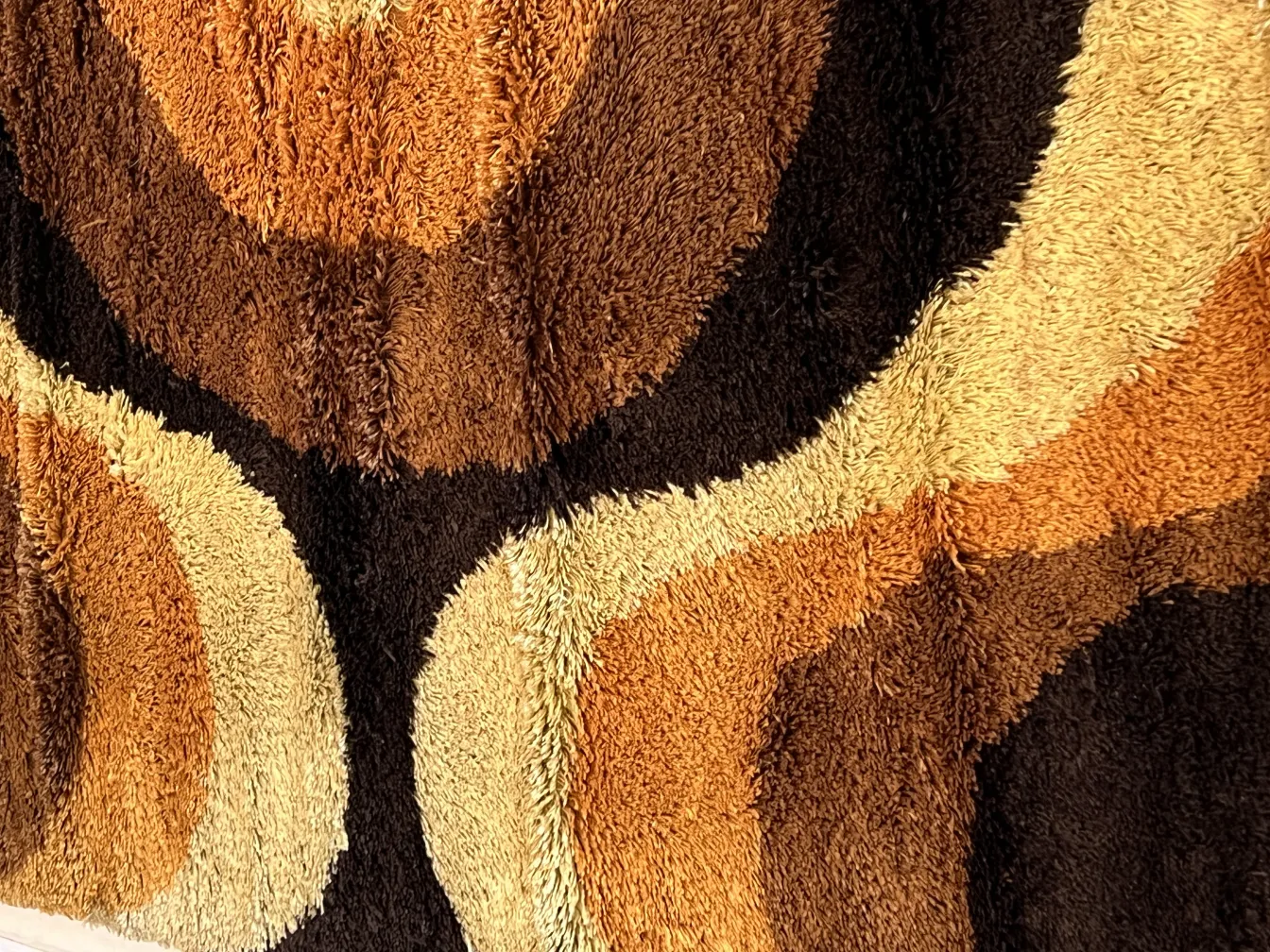 tappeto antico in tonalità di marrone e beige con motivi ondulati