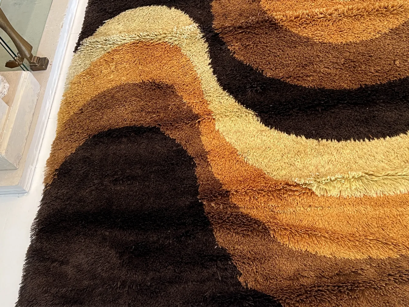 Alfombra antigua de tonos marrones y beige con patrones ondulados