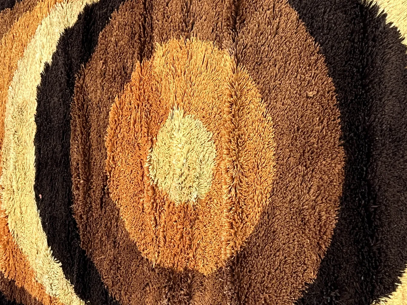 alfombra antigua con patrones circulares en tonos marrones