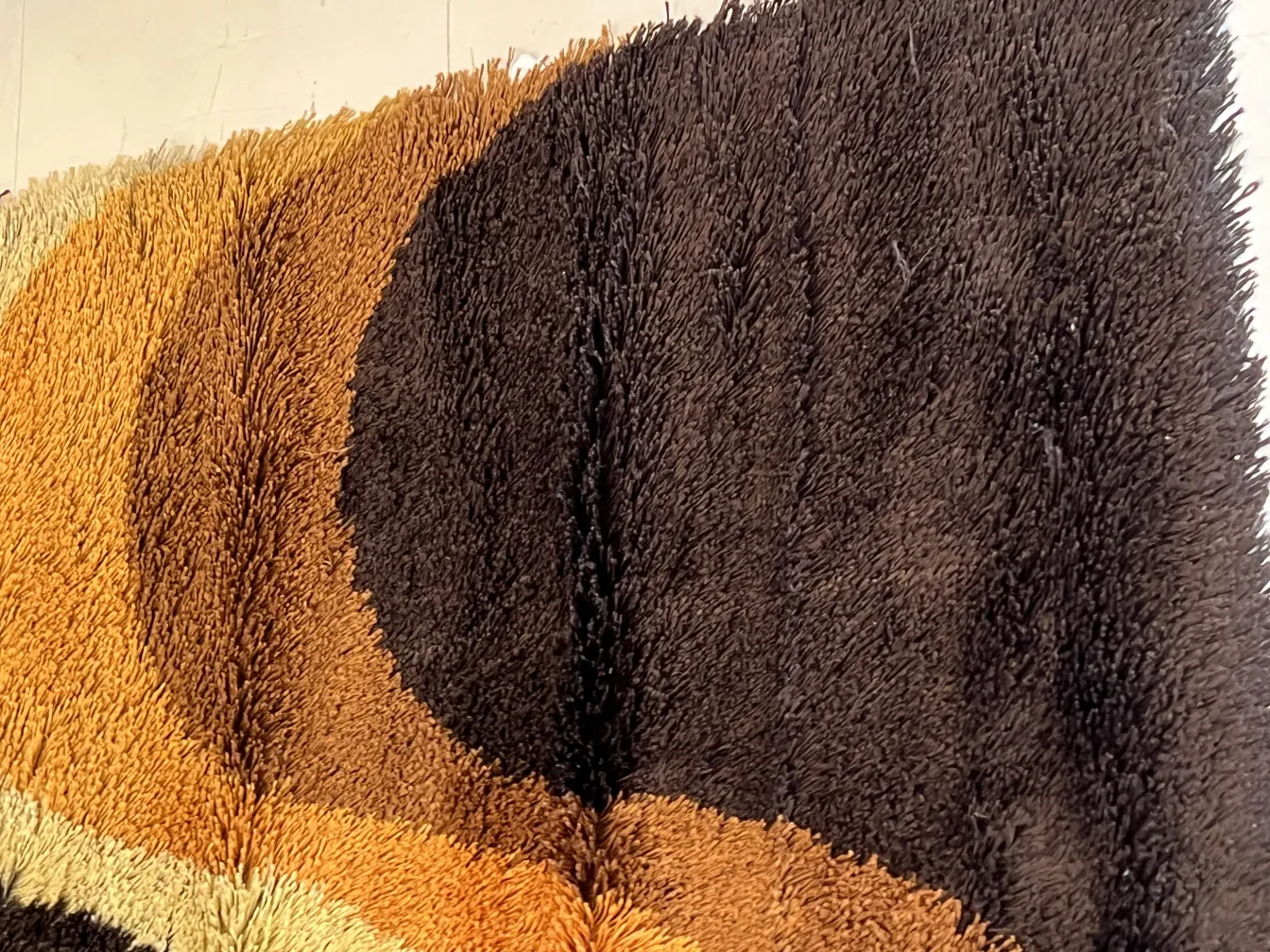 Tapis ancien aux couleurs douces dans des tons de marron et beige, ambiance chaleureuse.