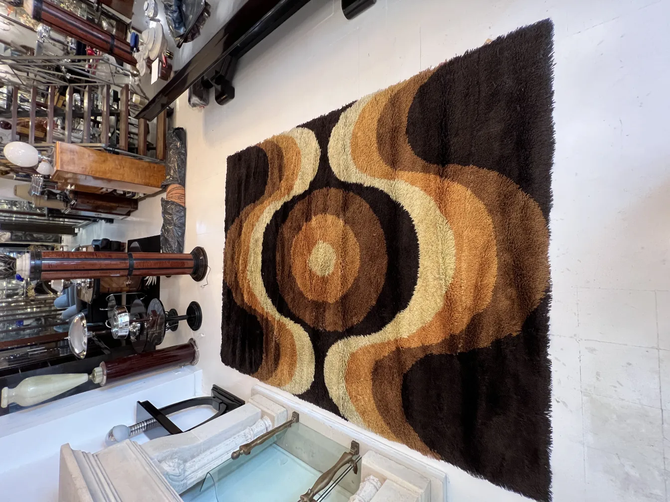 Antique carpet featuring brown and beige wavy design