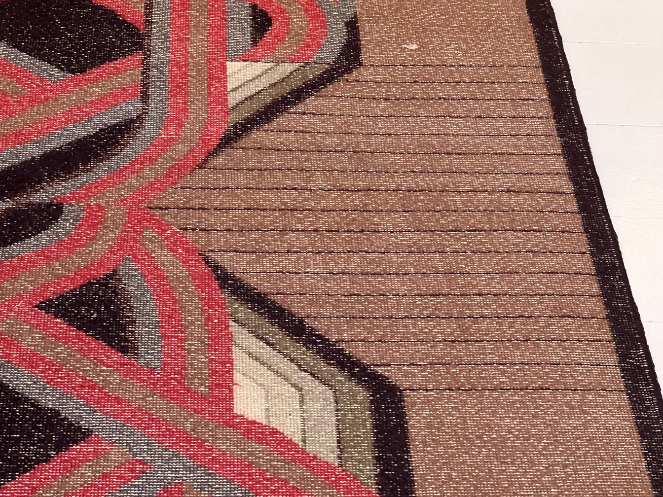 tappeto antico con design geometrico in toni scuri e chiari