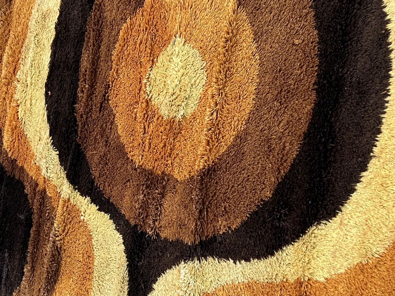 Antique carpet with circular design in shades of brown and cream