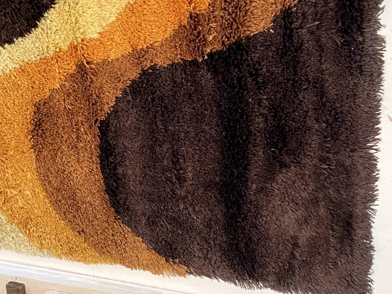 alfombra antigua con diseño en colores terrosos y texturizados