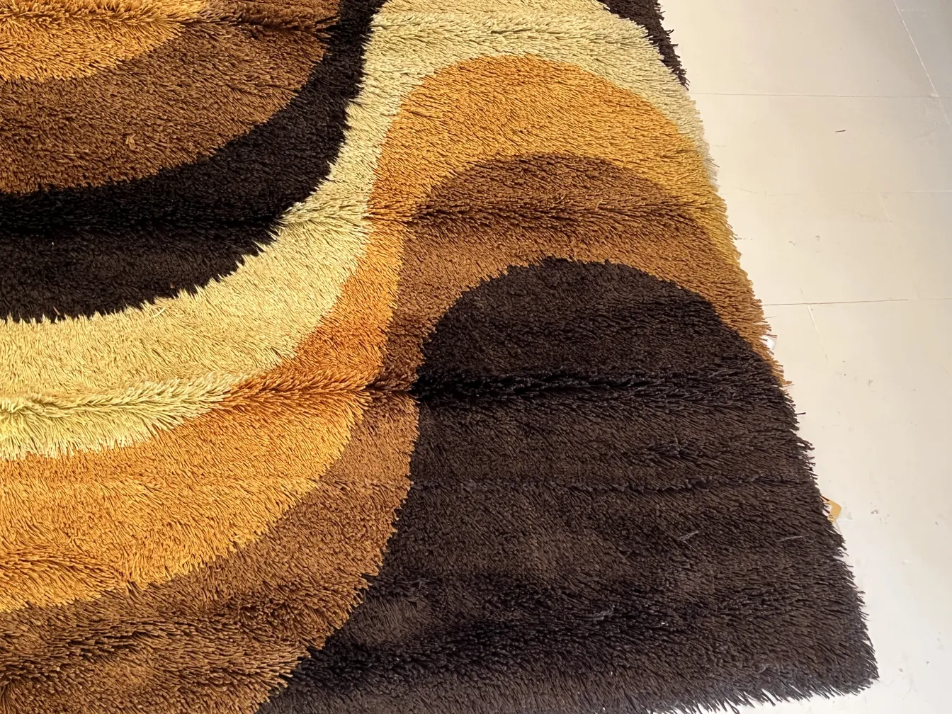 Tapis ancien avec des couleurs brunes et beiges, design organique