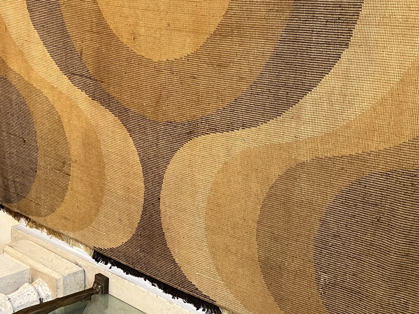 alfombra antigua con diseño de ondas en tonos beige y marrón