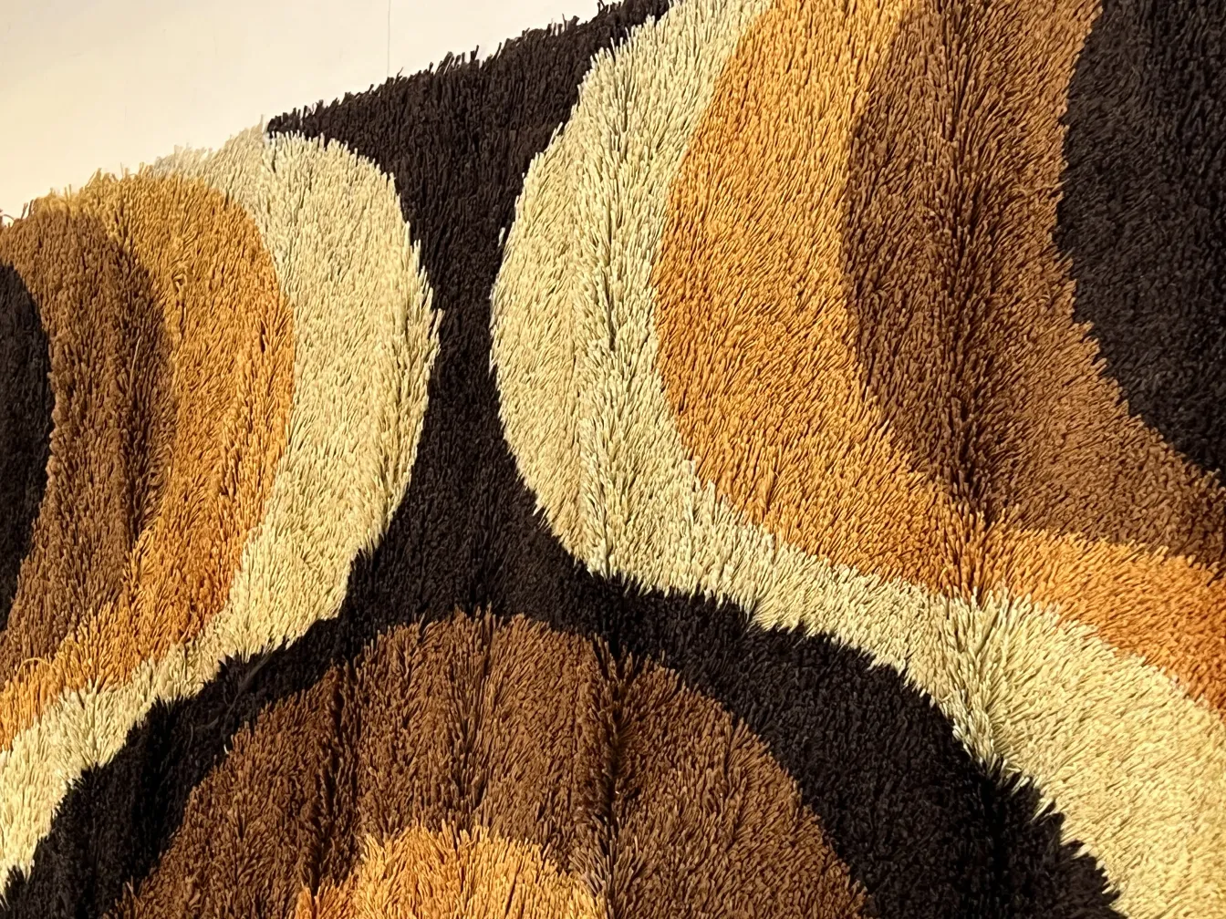 Antique carpet featuring brown and beige geometric patterns.