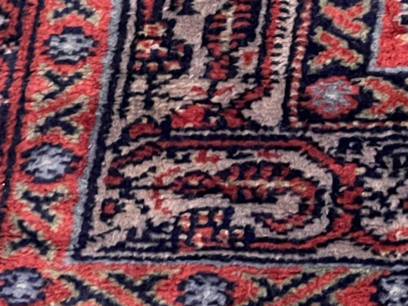 Alfombra antigua con diseño persa en tonos cálidos y fríos