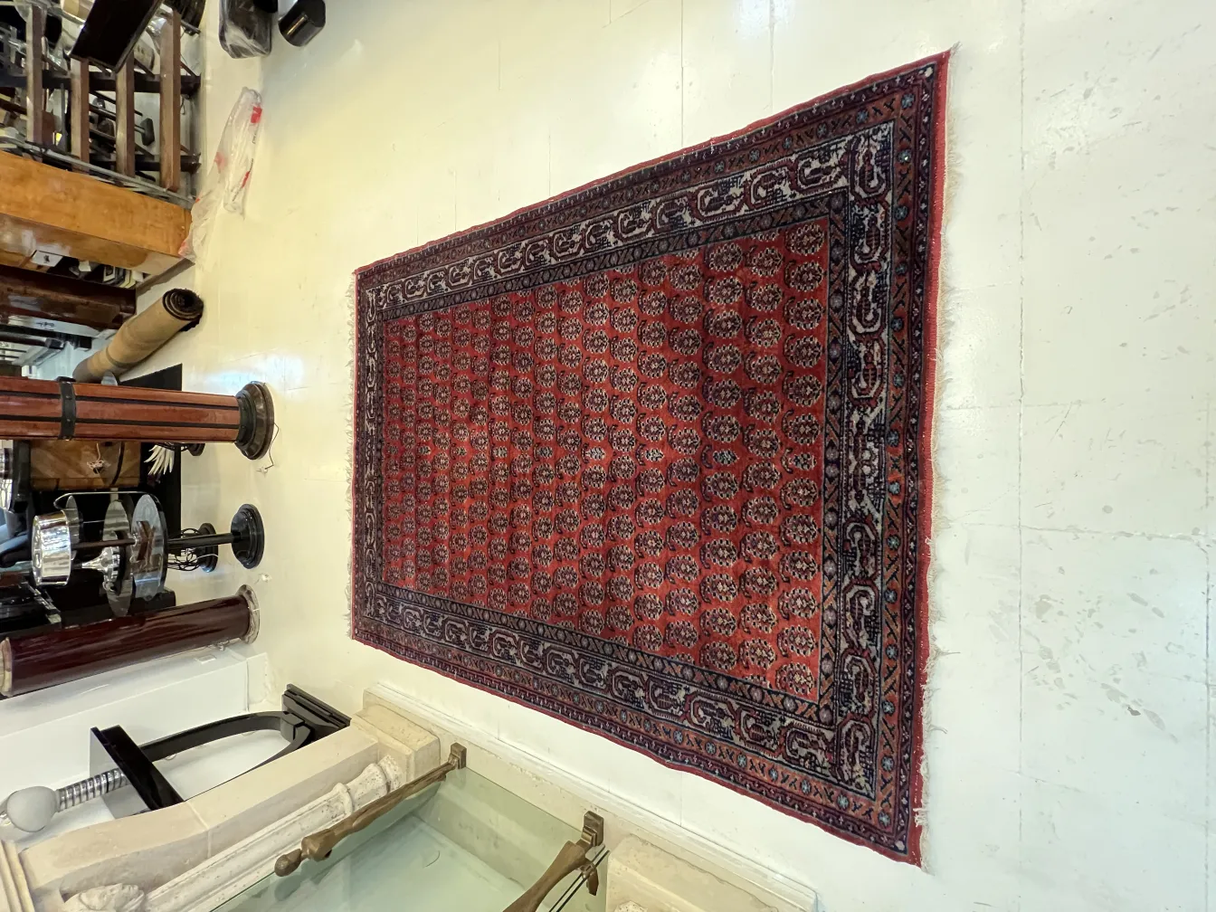 Alfombra antigua roja con bonitos diseños en un entorno vintage.