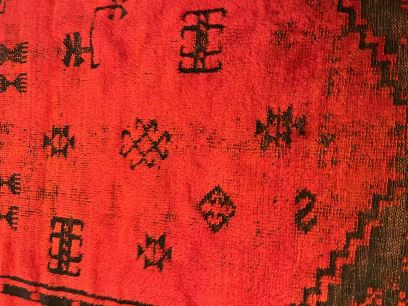 tappeto antico rosso con motivi e disegni intricati