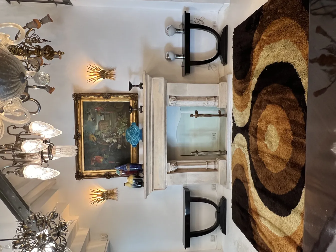 Alfombra antigua con diseños en forma de círculos en tonos marrones y cremosos, en un ambiente acogedor.