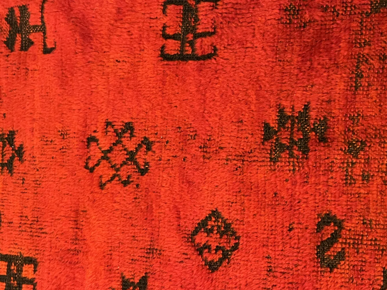 tapis ancien rouge avec détails noirs