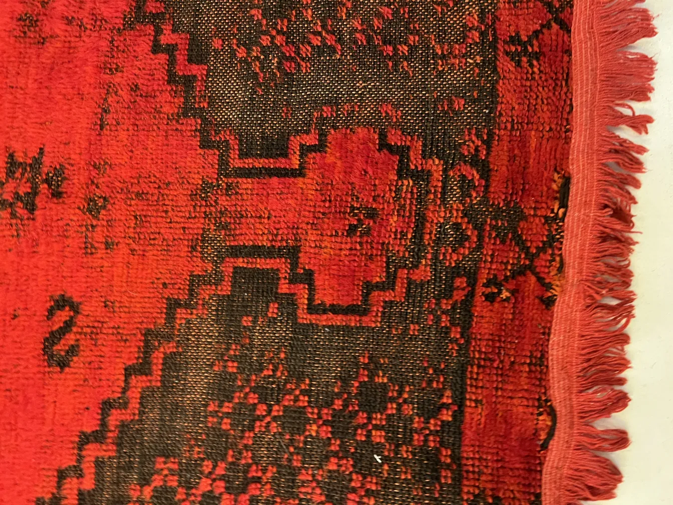 tapis ancien avec un design rouge et noir, ambiance confortable