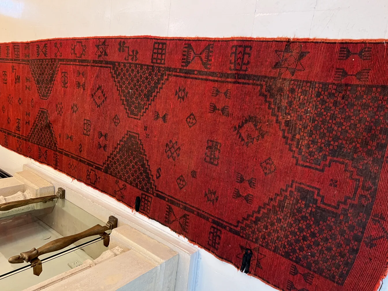 Tapete antigo vermelho com padrões decorativos pretos