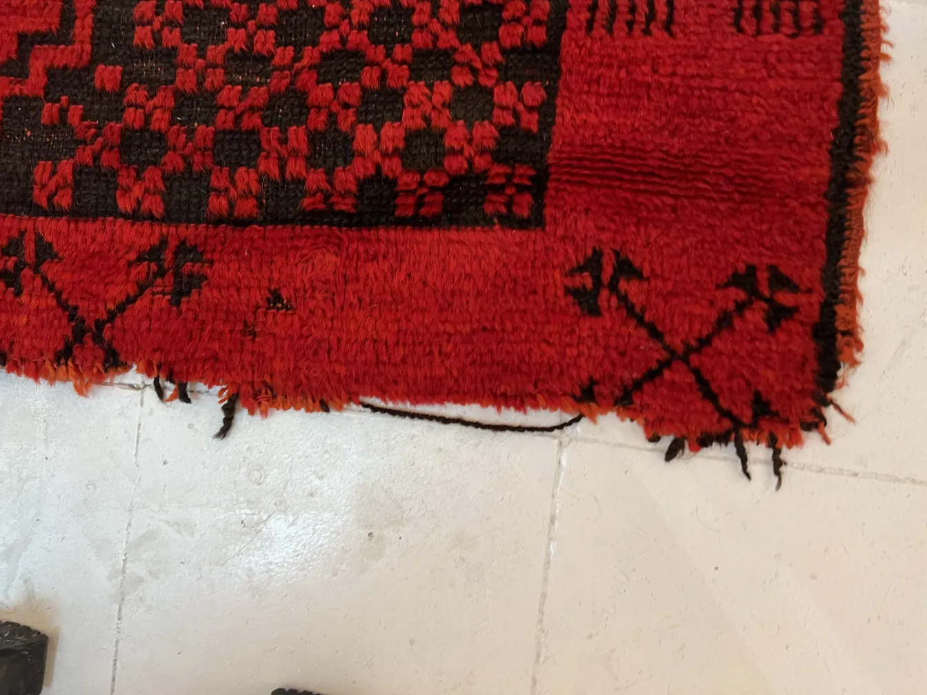 tapete antigo vermelho com figuras decorativas na borda