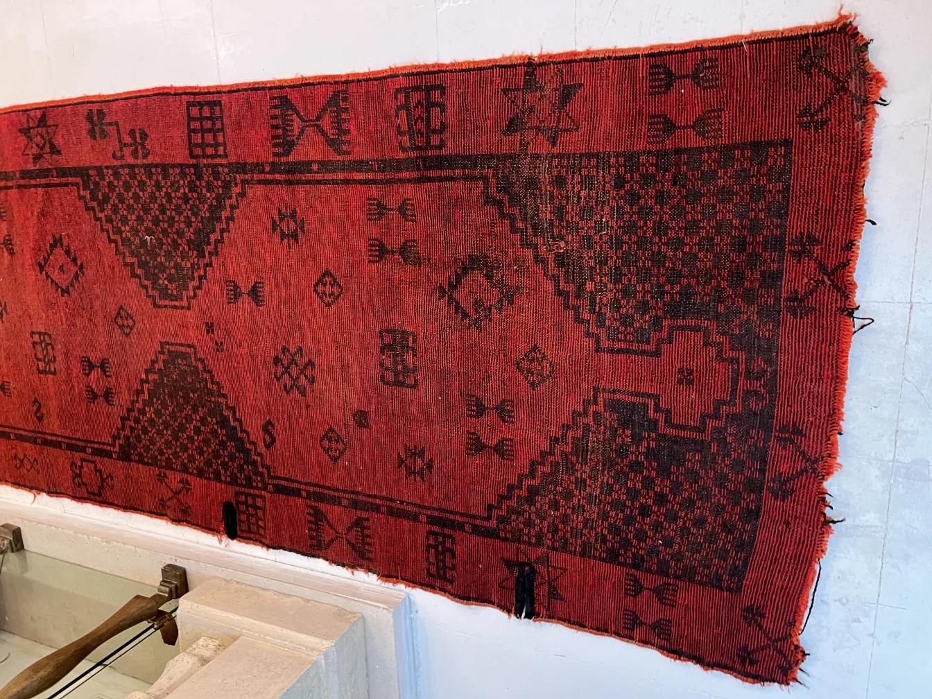 alfombra antigua con diseño geométrico rojo y negro