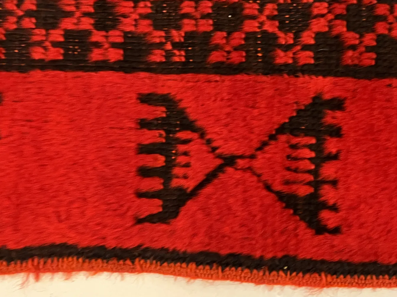 tapete antigo vermelho com padrões geométricos pretos