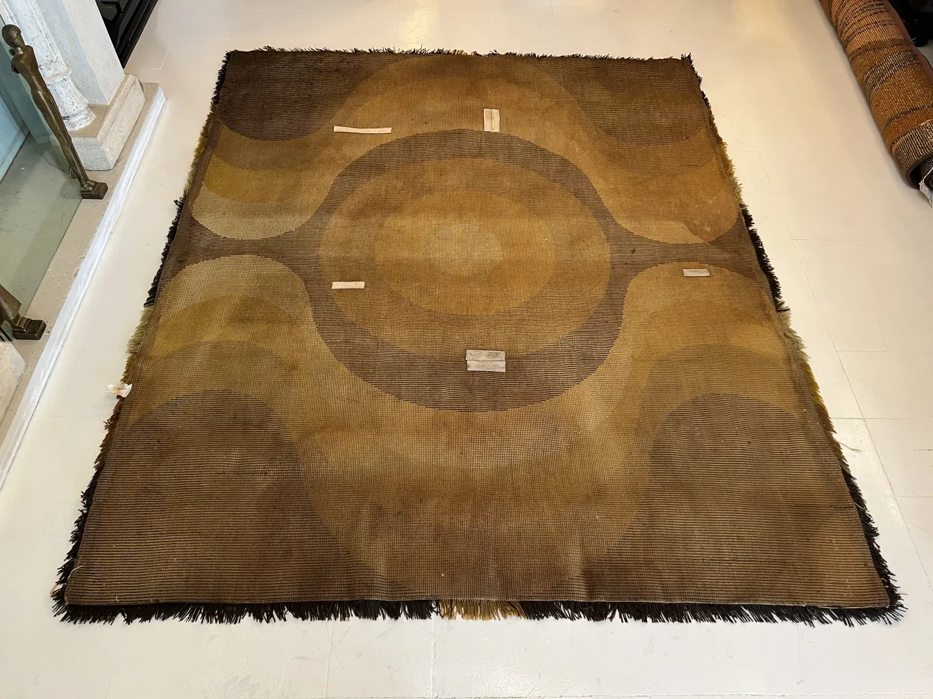 Alfombra antigua con patrones en tonos marrones y círculos