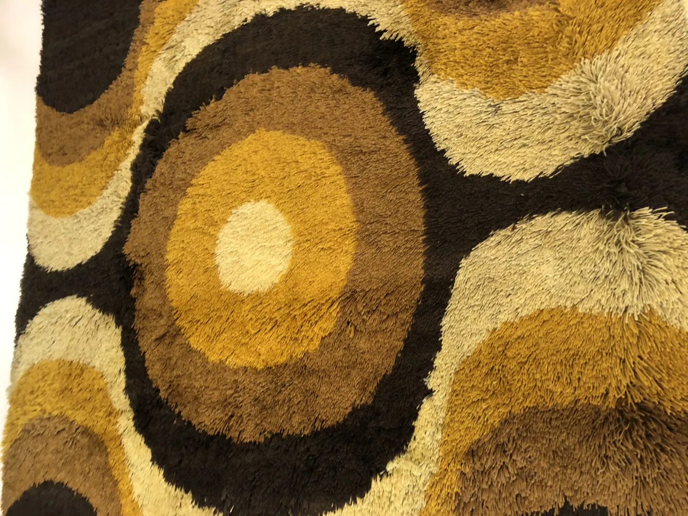 antique carpet featuring brown and beige circular design