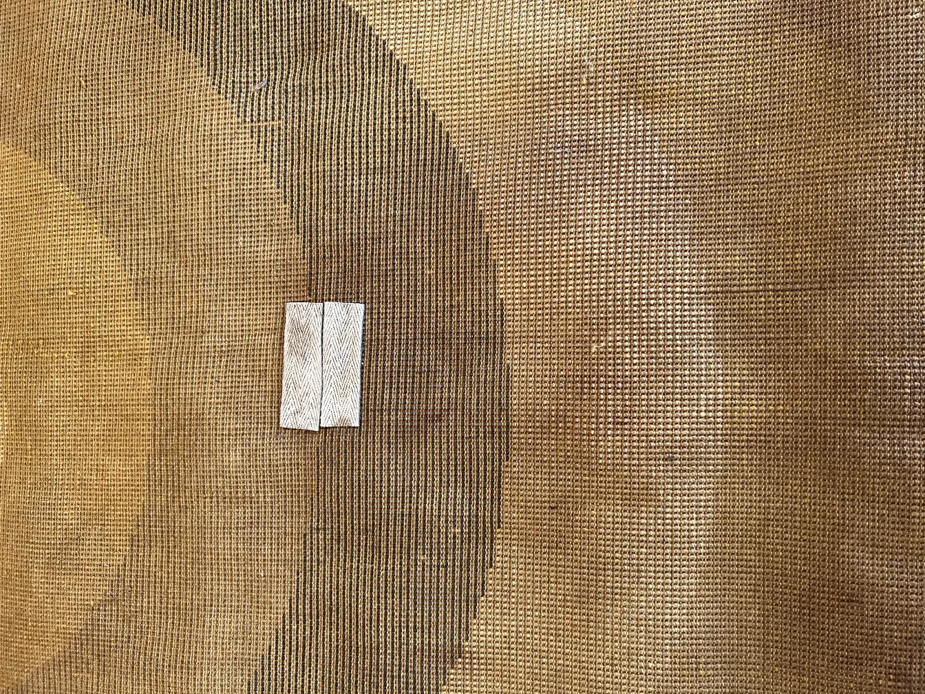 Tappeto antico con texture naturale in toni marroni e beige, atmosfera accogliente.