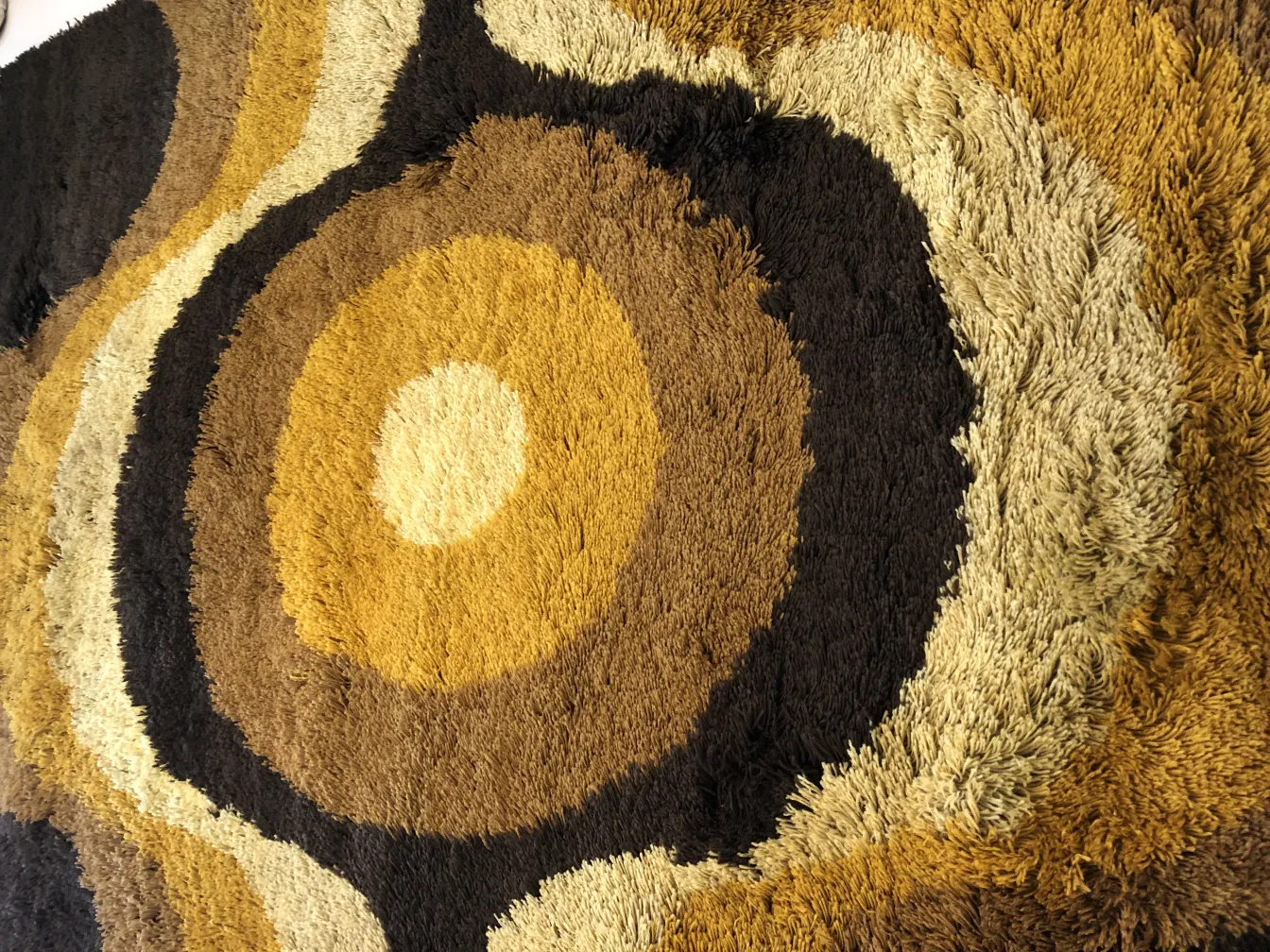 Tapis ancien avec des tons bruns et design circulaire